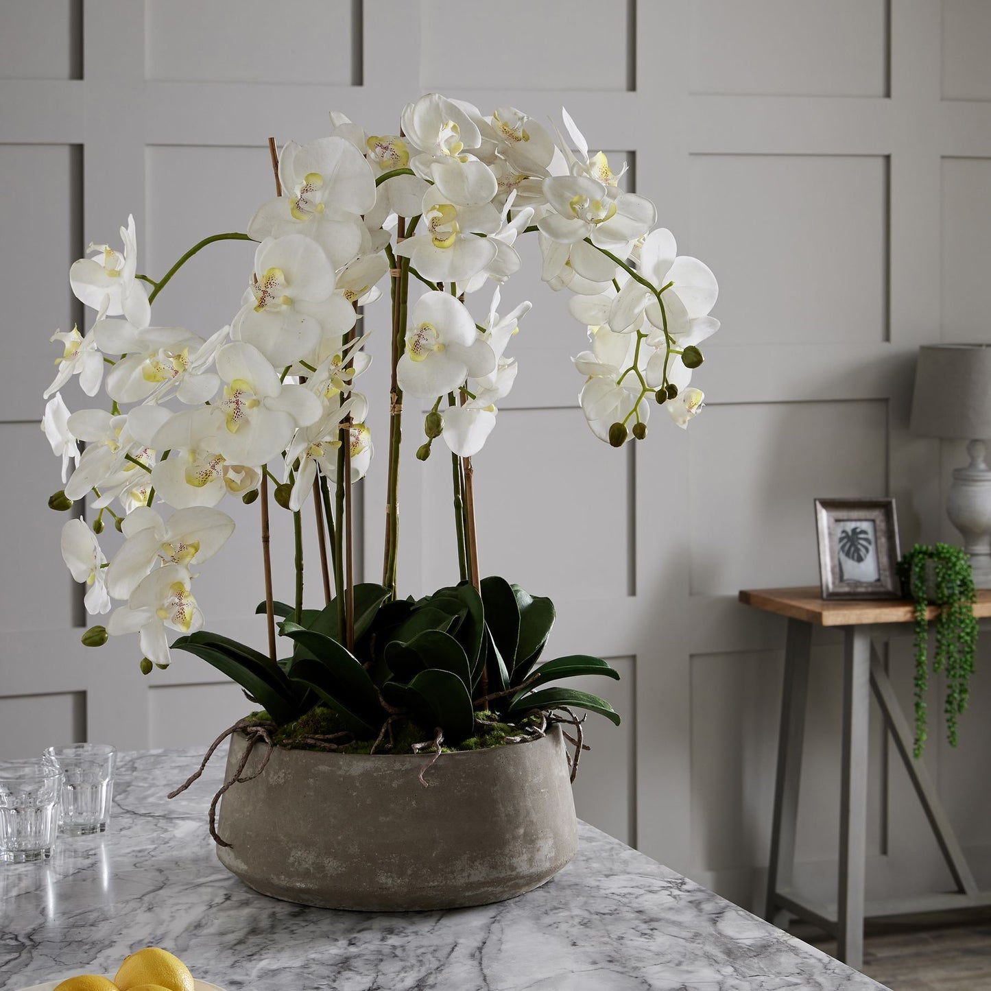 Artificial white orchid in rustic stone-effect pot with realistic petals and leaves