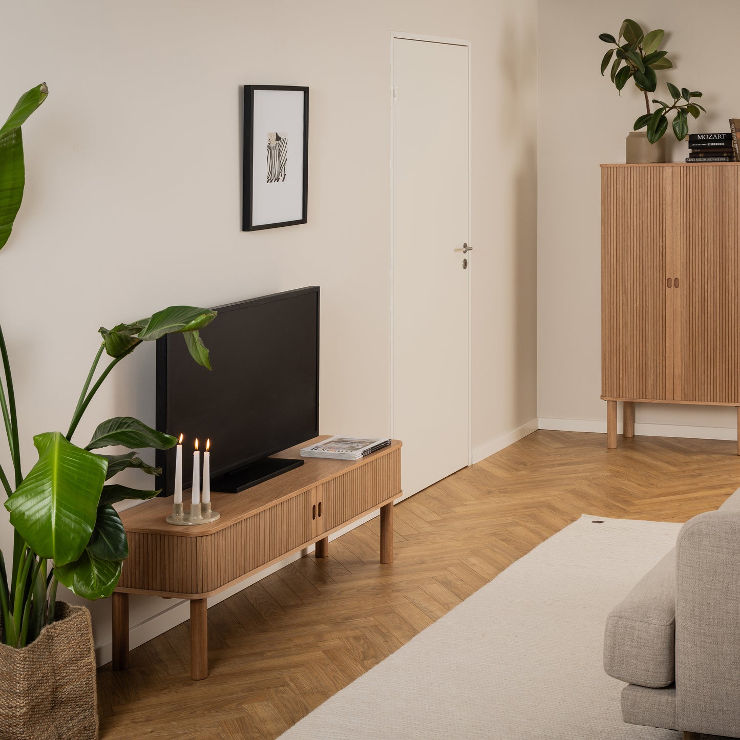 Oak coffee table with slatted tambour-style sliding doors, rounded corners, and open middle compartment, designed in a modern Scandinavian style.