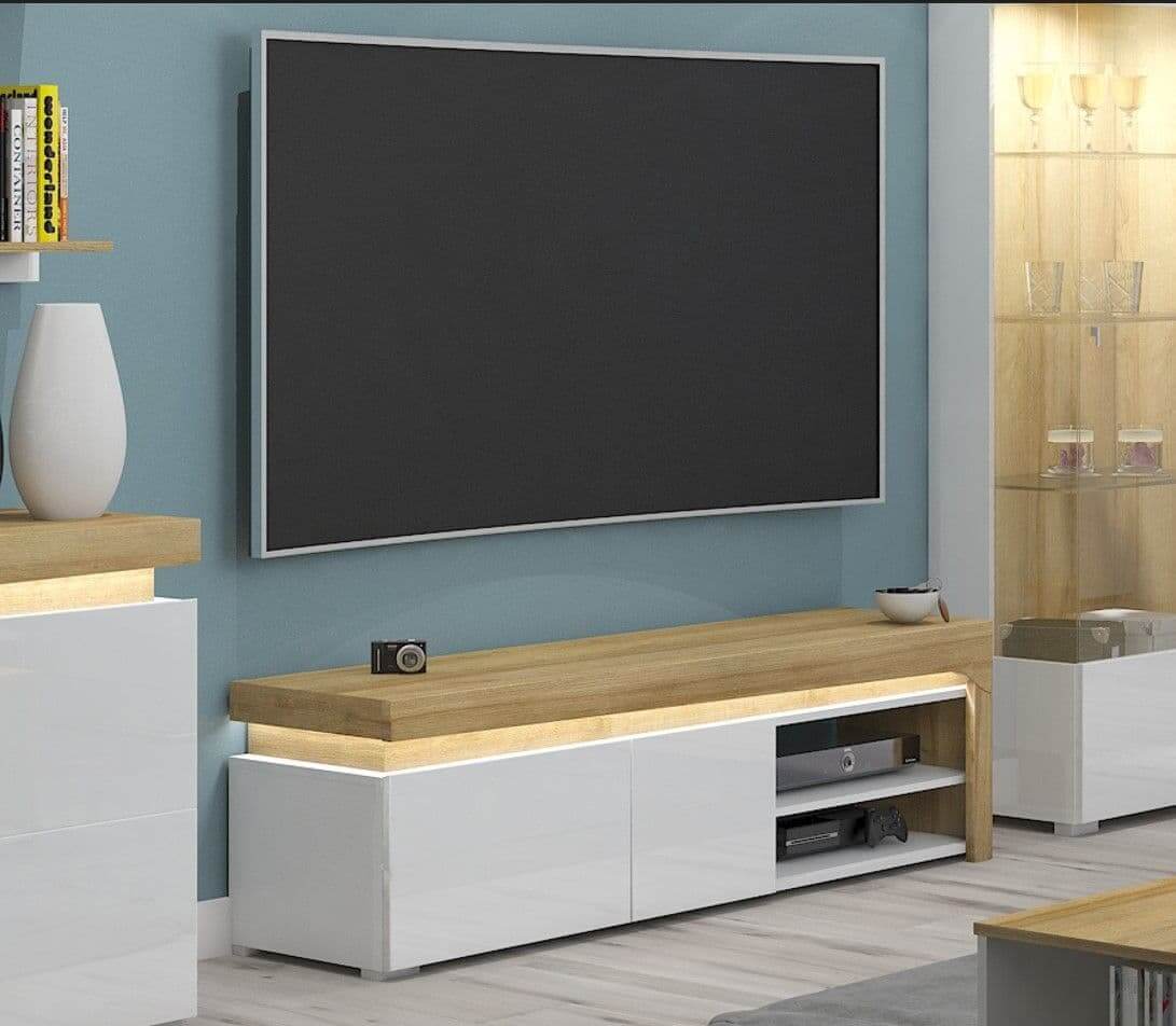 Modern living room with a large flat-screen TV mounted on a blue wall, below which is a wooden and white entertainment console.