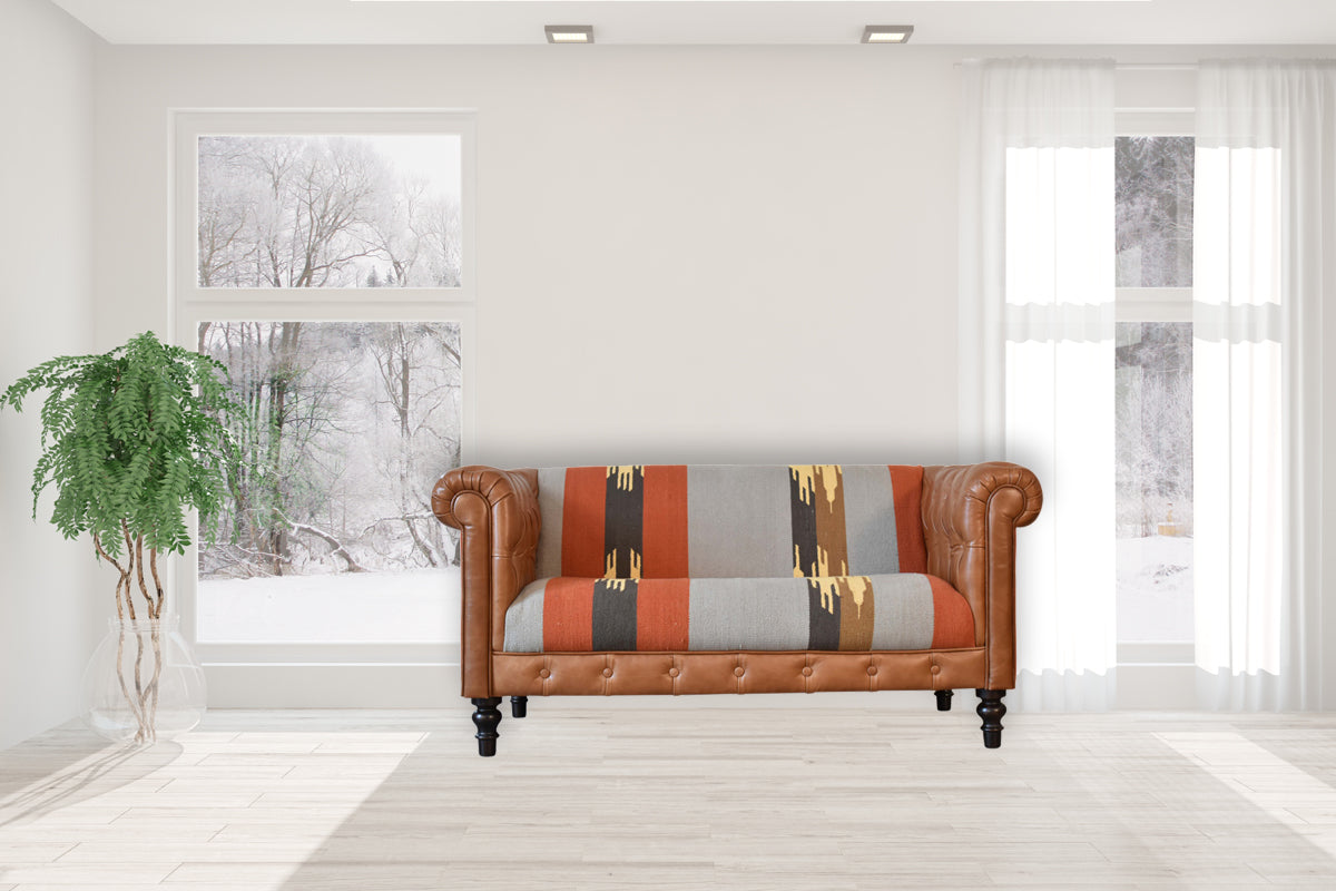 Handcrafted Kilim and Leather Chesterfield Sofa featuring a tufted tan leather frame, traditional rolled arms, and a bold multicolour kilim upholstery with geometric patterns, blending rustic charm and contemporary design.