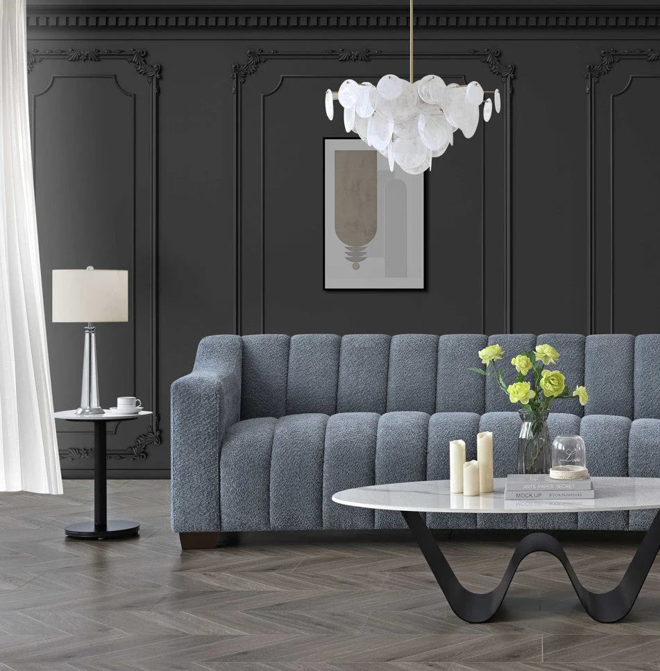Aluxo Astoria 3 seater sofa in iron bouclé fabric with deep channel stitching and soft curved edges, styled in a modern, luxurious living room setting.