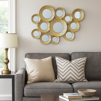 Decorative wall mirror with circular mirrors above a gray sofa with patterned cushions.