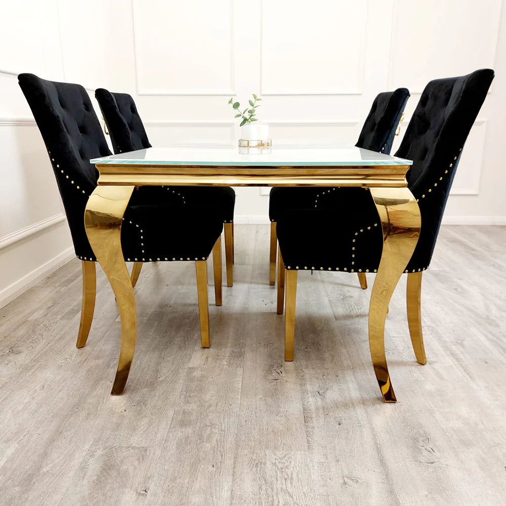 Black velvet lion knocker dining chair with gold detailing, quilted back, and studded trim, styled with a marble and gold dining table in a luxury setting.