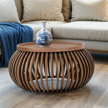 Indus small round coffee table in pale taupe mango wood with slatted design and built-in shelf, styled in a modern neutral-toned living room.