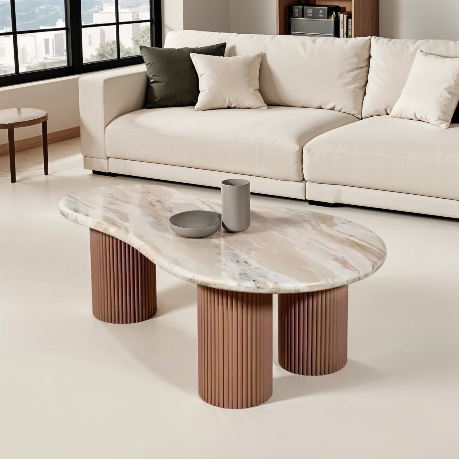 Ashford marble pedestal coffee table with natural stone top and ribbed taupe mango wood base, styled in a modern interior with warm neutral tones.
