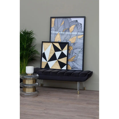 Two framed artworks on a wall with a black cushioned chair and small table.